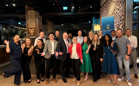 UCD alumni at the Dubai gathering, standing together and smiling during an evening event celebrating the UCD alumni community in the UAE.